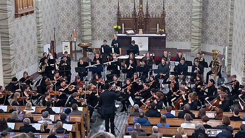 Das Jahresabschlusskonzert in der Lukaskirche. Das HTWK Orchester ist von schräg oben vor dem Altar zu sehen.