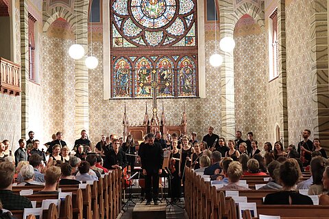 Das Sinfonieorcherster der HTWK beim Spielen in einer Kirche.