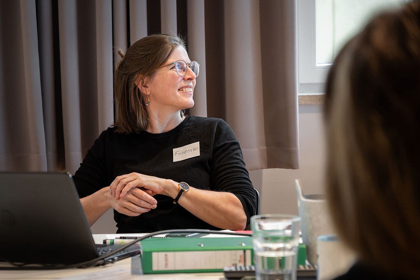 eine Frau sitzt am Tisch und lacht