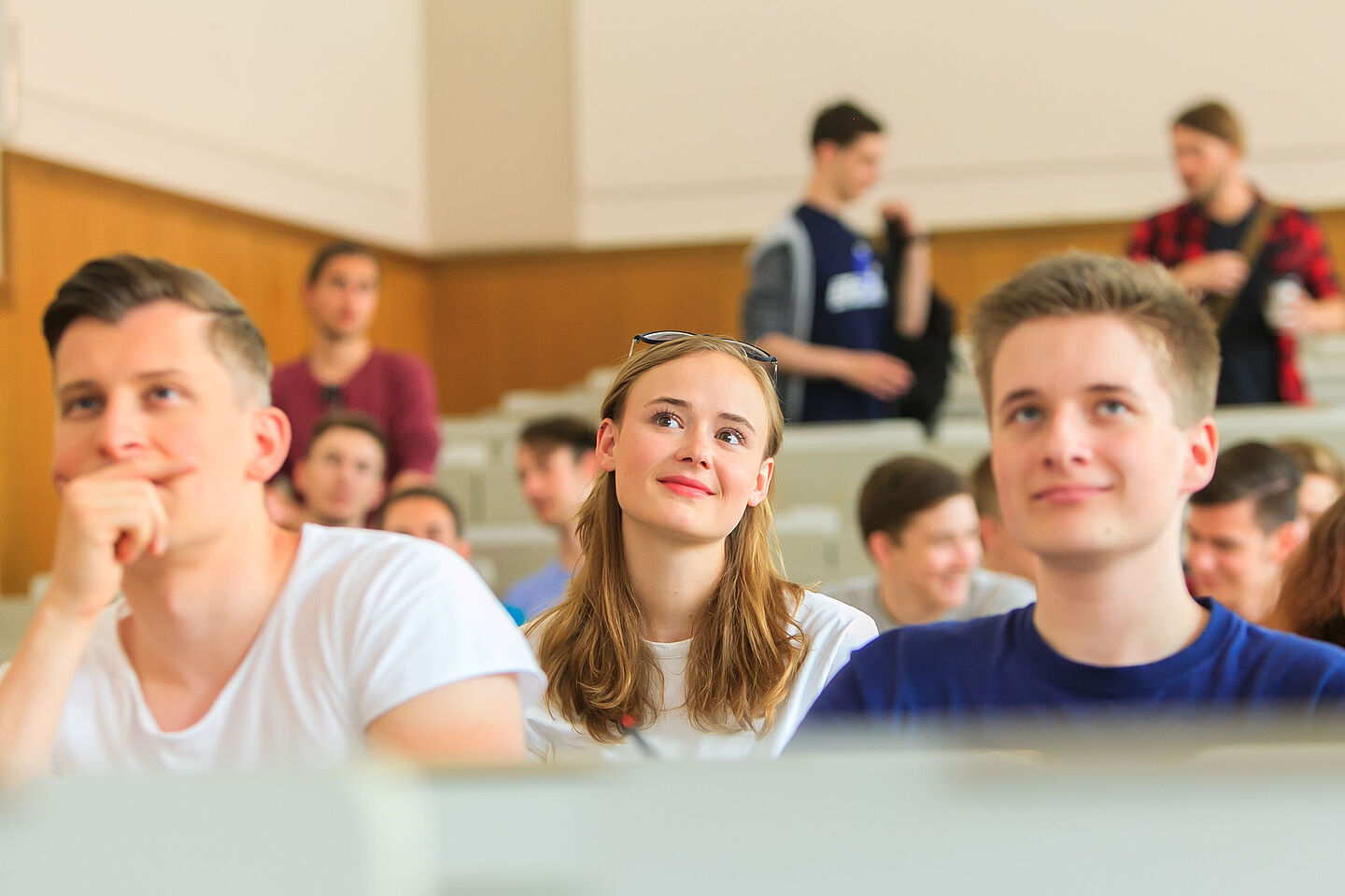 Illustration: Studierende sitzen in einem Hörsaal und lauschem dem Vortrag.