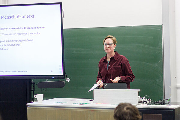 Keynote von Dr.in Steffi Nothnagel am 04.12.24 an der HTWK Leipzig Auf dem Bild steht Dr.in Nothnagel hinter einem Pult und hält ihre Keynote. Neben ihr ist der Bildschirm mit ihrer Präsentation zu sehen.