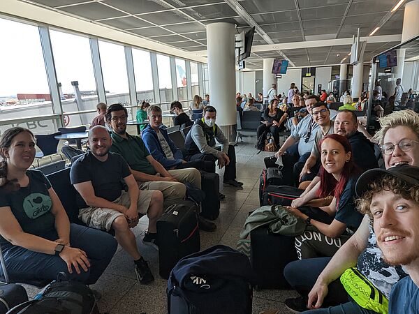 viele Leute sitzen und warten in Flughafen