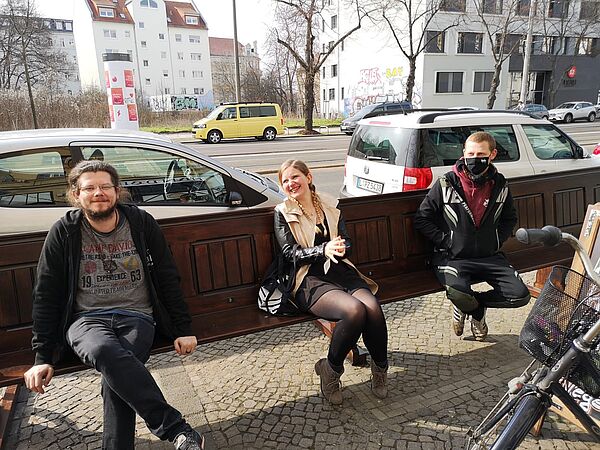 Lubo, Sabine und Jonas sitzen auf einer Parkbank