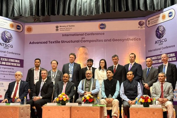 Ehrengäste und Keynote-Speaker der ATSCG 2026 Mehrere Personen sitzen und stehen auf einer Bühne für ein Gruppenfoto