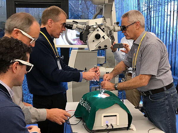  Die Chirurgen Dr. Steven Theiss und Dr. Andreas Korge demonstrieren den Kursteilnehmer die Vorgehensweise bei einer Bandscheibenoperation.