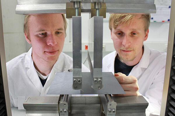 Professor Stephan Schönfelder (links) von der HTWK Leipzig und Felix Kaule vom Fraunhofer CSP am 4-Punkt-Biegeversuch mit einem polykristallinen Siliziumwafer