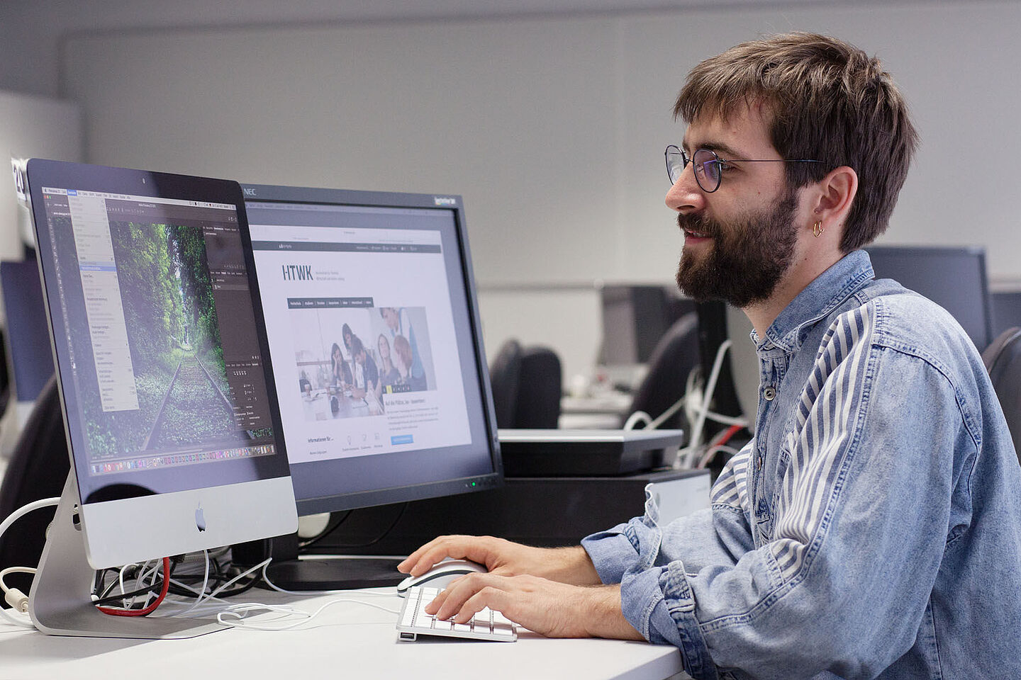 Person sitting at a desk in front of two screens