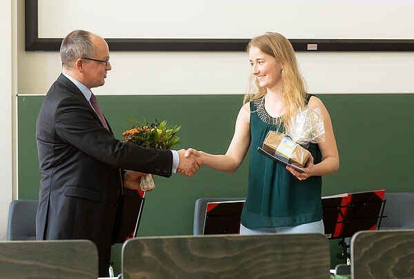 Mann gratuliert Frau in Hörsaal