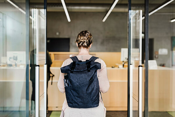 Eine Studentin geht in die Bibliothek