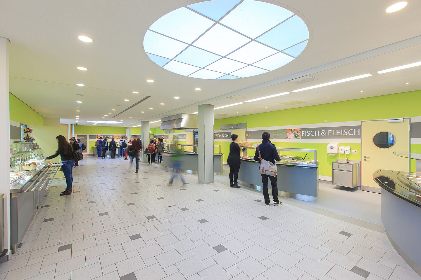 Large room with several counters for serving food and a salad bar