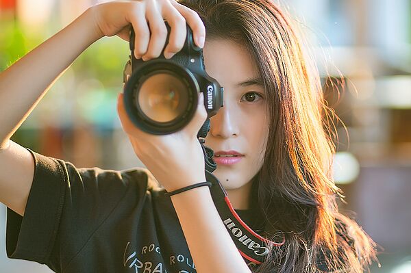 eine junge Frau fotografiert mit einer guten Kamera