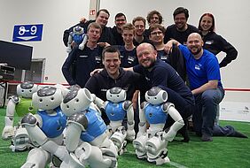 Gruppe von Menschen mit humanoiden Robotern