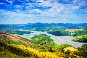 DINOBBIO Grüne, bergige Landschaft mit einem See und blauem Himmel