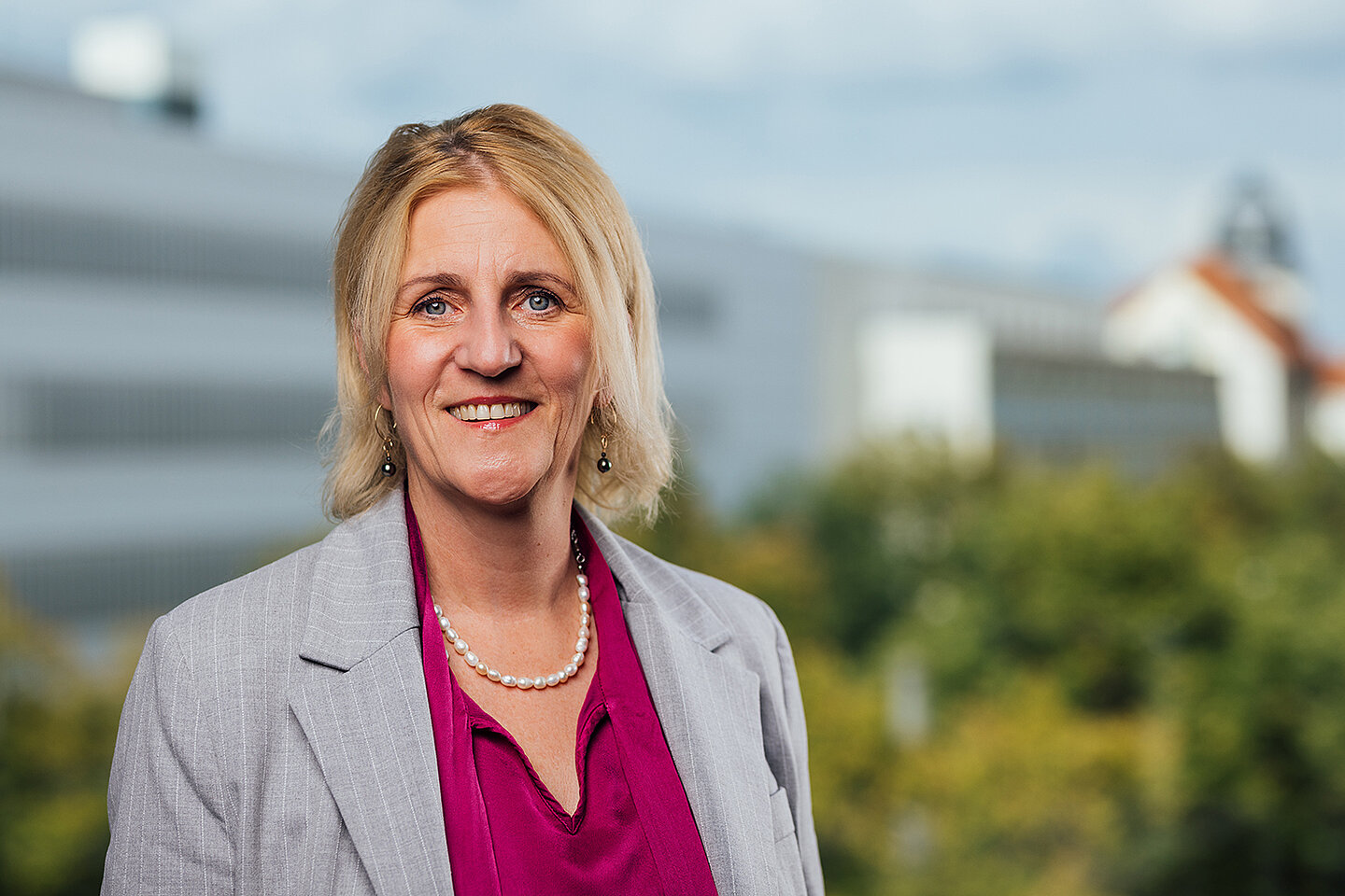 Kanzlerin Prof. Dr. Swantje Rother Portrait einer lächelnden Person vor einem Hochschulgebäude