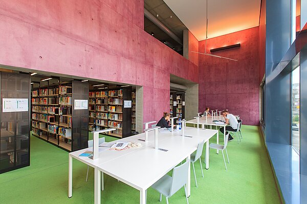 Hochschulbibliothek der HTWK Leipzig. (Foto: Swen Reichhold/HTWK Leipzig) Drei Personen sitzen mit Abstand an Tischen in der Bibliothek.