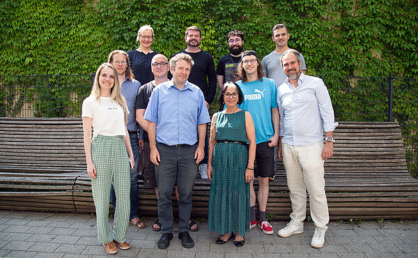 Brasilianische und deutsche Forschende versammeln sich zum Teamfoto vor einer grünen Wand