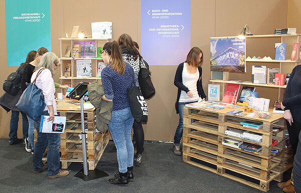 Interessierte schauen sich die Ausstellungsstücke am Gemeinschaftsstand von Studierenden der Buch- und Medienwissenschaft aus ganz Deutschland an