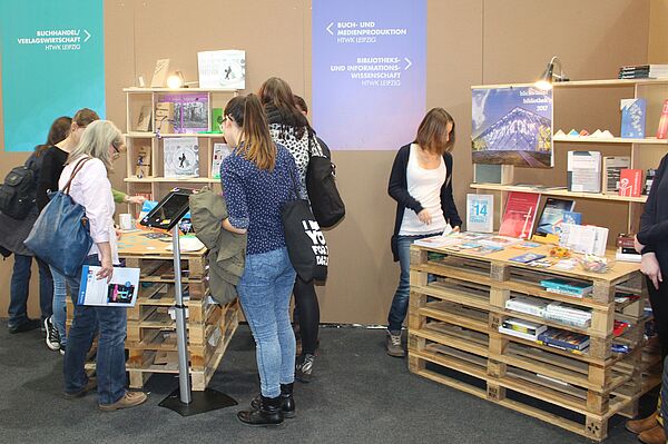 Interessierte schauen sich die Ausstellungsstücke am Gemeinschaftsstand von Studierenden der Buch- und Medienwissenschaft aus ganz Deutschland an