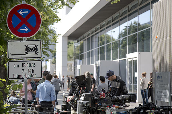 Viele Menschen und viel Kamera-Equipment befinden sich vor dem Nieper-Bau