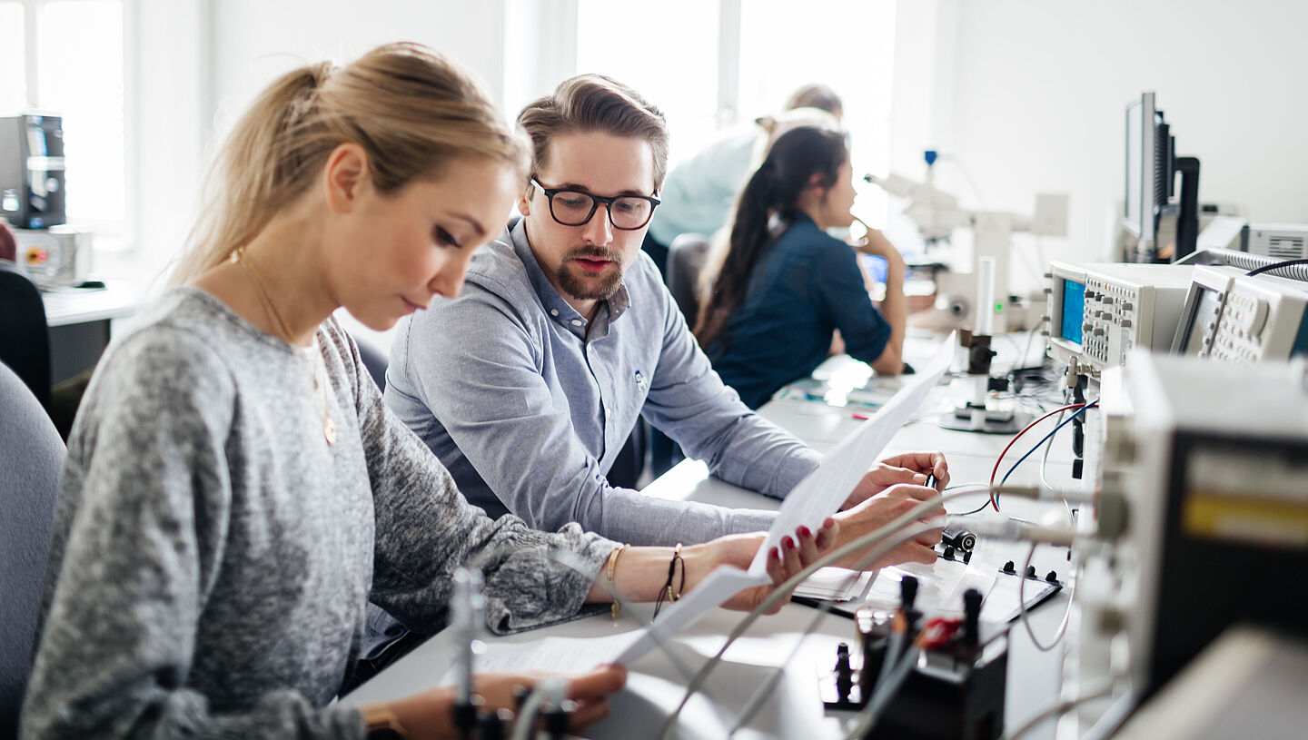 zwei Personen an elektronischen Geräten