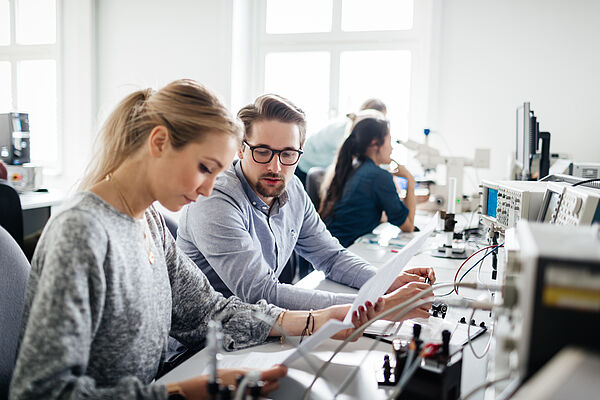 zwei Personen an elektronischen Geräten