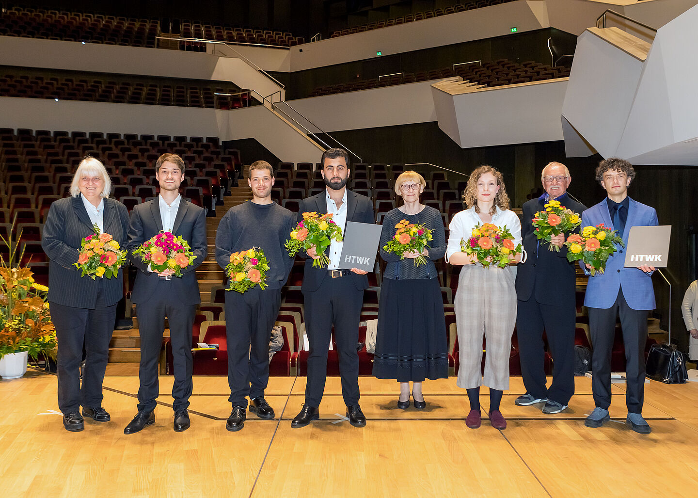 8 ausgezeichnete Personen mit Blumen im Gewandhaus