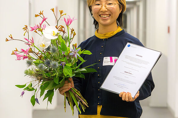 junge Japanerin mit Blumen und Urkunde