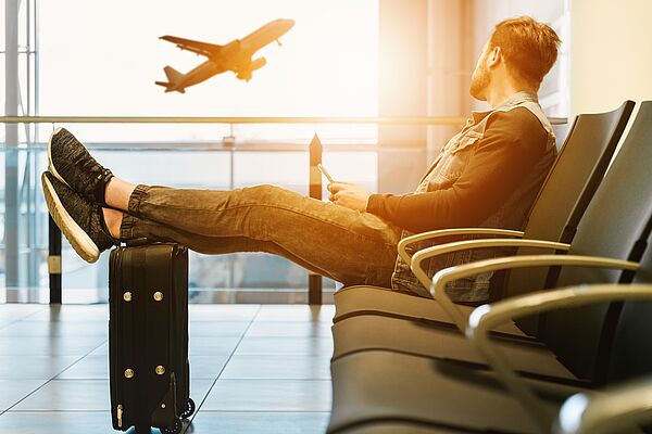 Mann sitzt am Flughafen