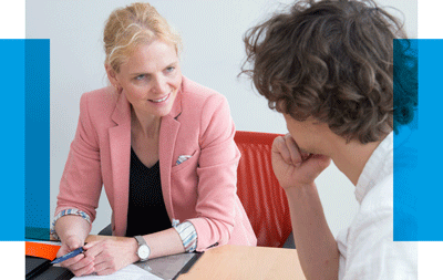 Gemeinsam eigene Ziele reflektieren. Eine Professorin und ein Mann unterhalten sich.