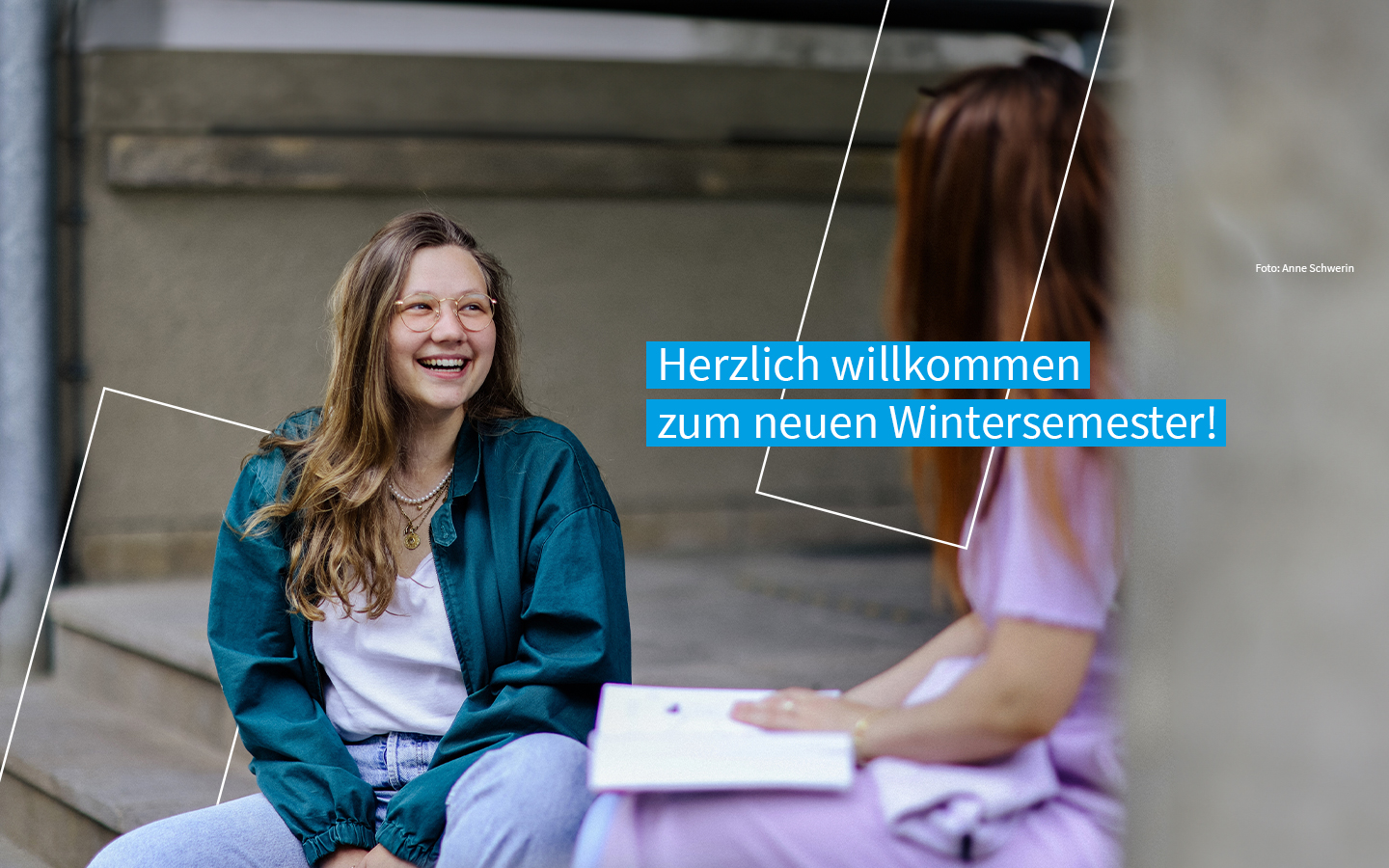 Studentin sitzt freudestrahlend im Trefftz-Bau Eingangsbereich und unterhält sich mit einer Kommilitonin. Auf dem Bild befindet sich der Text "Herzlich willkommen zum neuen Wintersemester!"